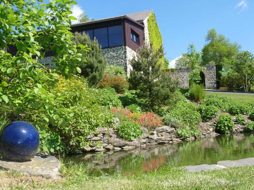 a house with a garden and a river at Le Clos de Saussac in Yssingeaux