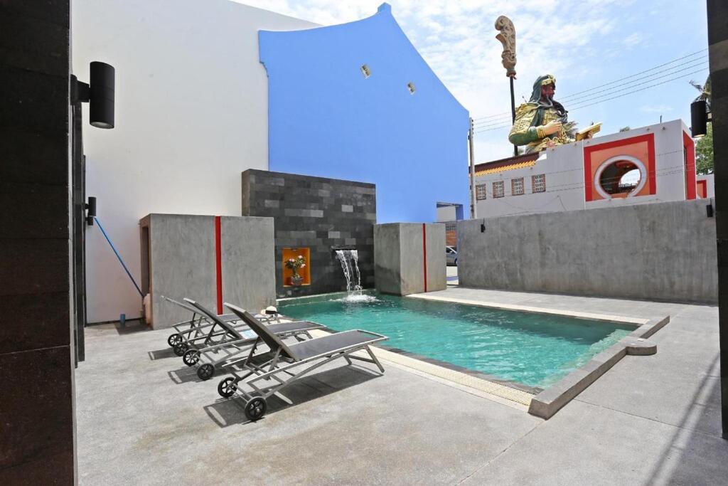 a group of chairs sitting next to a swimming pool at Guan Yu Boutique Hotel in Ban Thong Yi