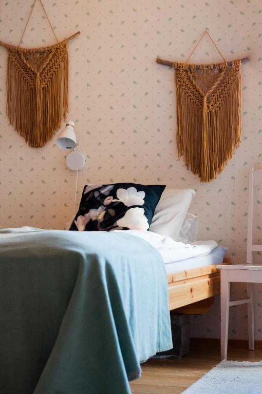 a bedroom with a bed with a green comforter at Majatalo Puukarin Pysäkki in Nurmes