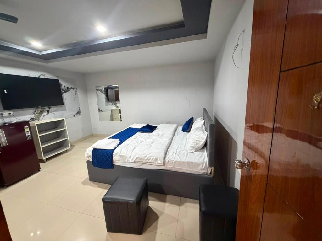 a bedroom with a bed and a flat screen tv at HOTELc3 in Visakhapatnam