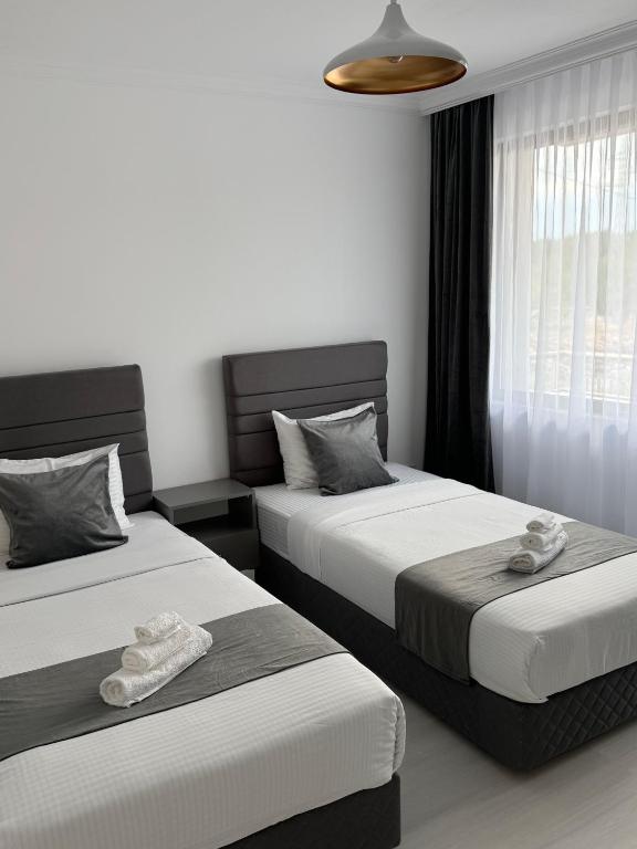 two beds in a hotel room with towels on them at Millennium Guest House in Kŭrdzhali