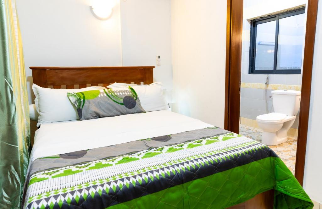 a bedroom with a bed and a toilet at BJ House in Douala