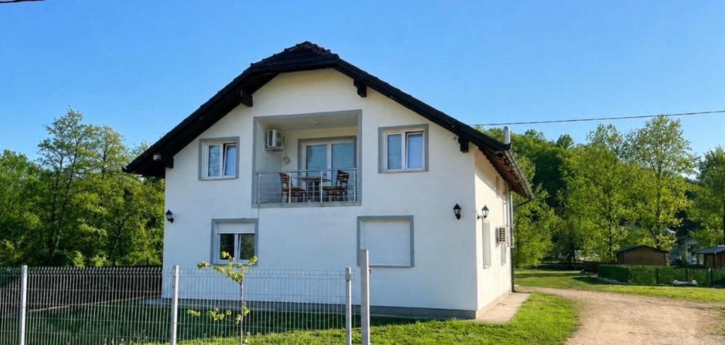 a white house with a black roof at Domaćinstvo Kondić in Podovi