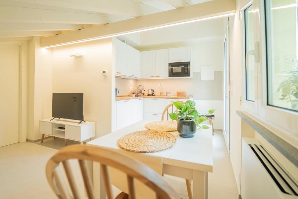 a kitchen with a table with two chairs and a television at Ulivo, Relax a due passi dal mare in San Lazzaro