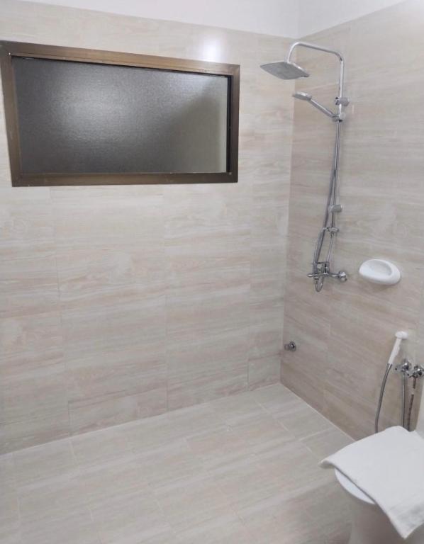 a bathroom with a shower with a mirror at Nahda Tower Suite in Salalah