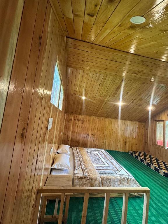 a large wooden room with a bed in a sauna at the jibhi nest cottage in Mandi