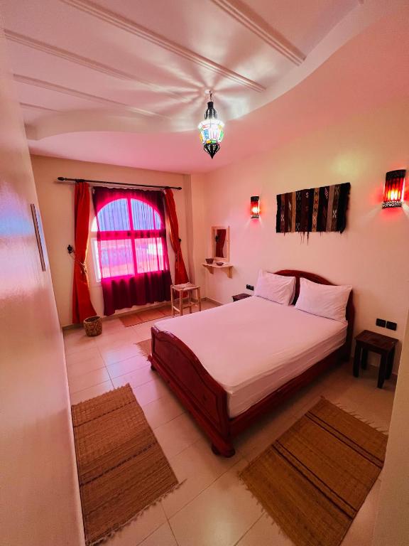 a bedroom with a large bed and a window at Zakar Apartments & Terrace in Mirleft