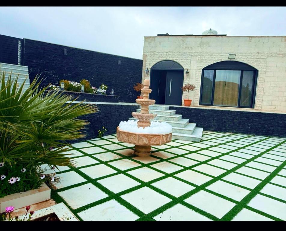 a fountain in the middle of a courtyard with a building at Casablanca chalet in Umm Nūwārah