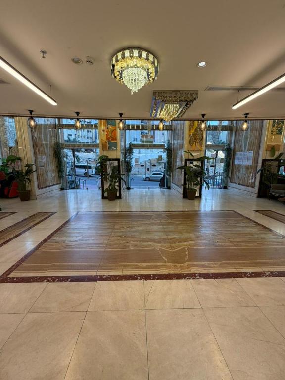 a large empty lobby with a chandelier in a building at Al Maqam Alsharqy Shuttle Srevice to Haram in Mecca