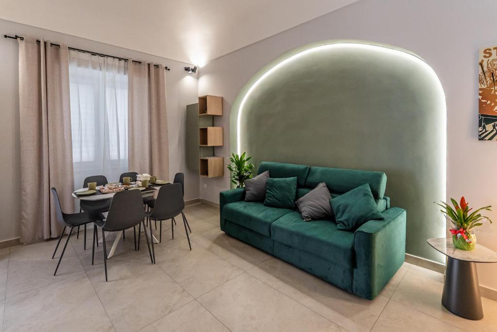 a living room with a green couch and a table at Barrio La Suite del Borgo Bacoli in Bacoli