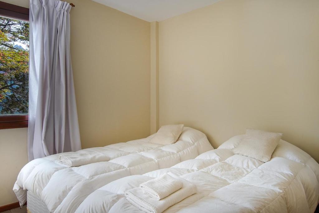 two white beds in a room with a window at Rancho del Lago in San Carlos de Bariloche