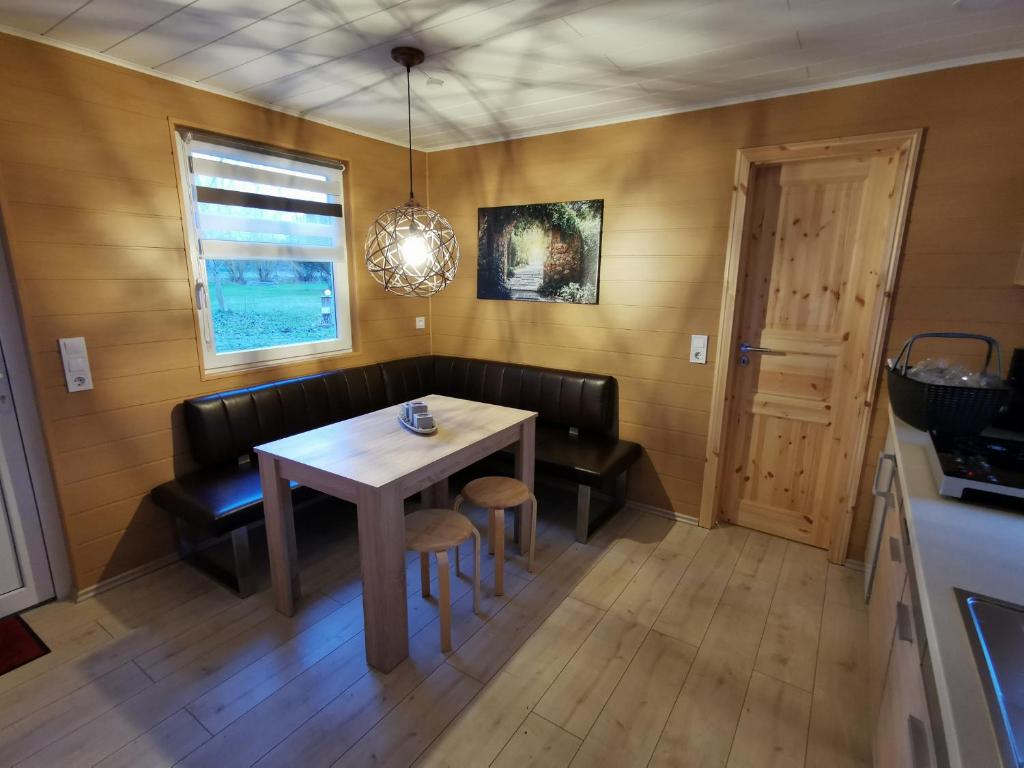 a dining room with a table and chairs and a window at Bungalow Seedorf 6 in Basedow
