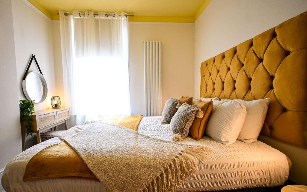 a bedroom with a large bed with a large headboard at Radnor Rest in Folkestone
