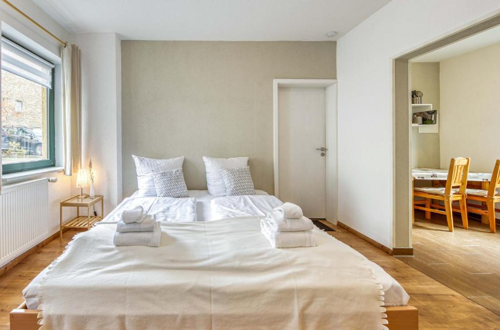 a bedroom with a large white bed with towels on it at Am Müritzer Hafen App 1 in Waren