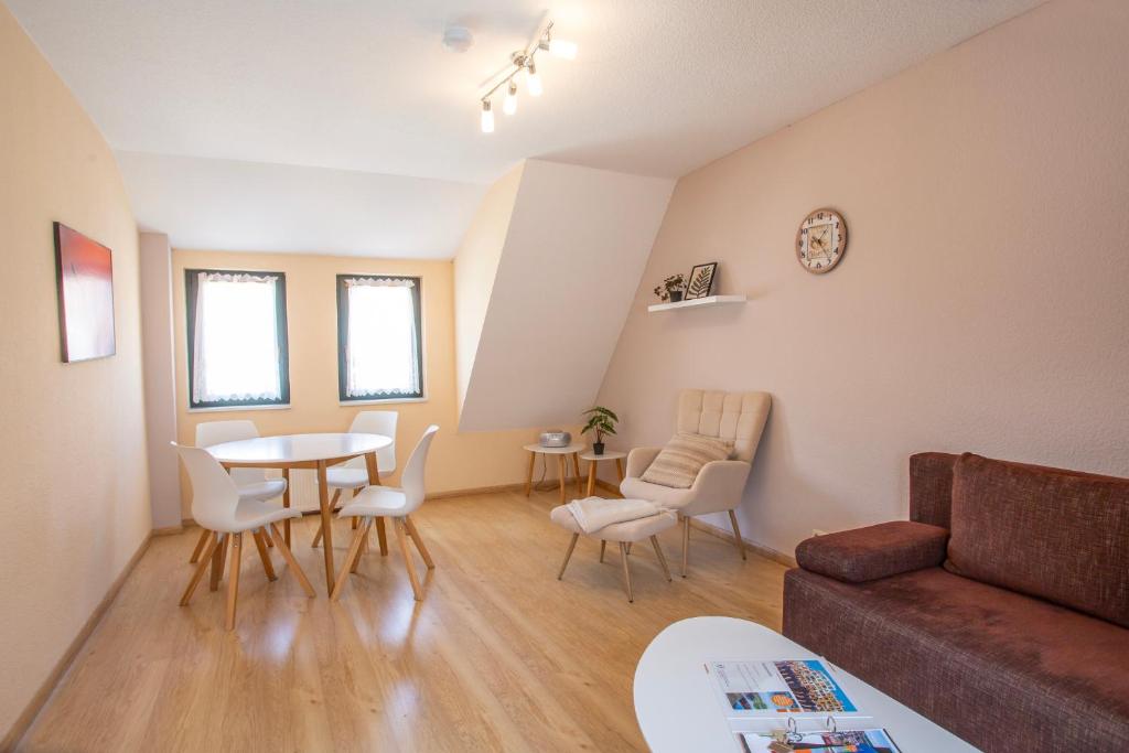 a living room with a couch and a table and chairs at Am Müritzer Hafen App 4 in Waren