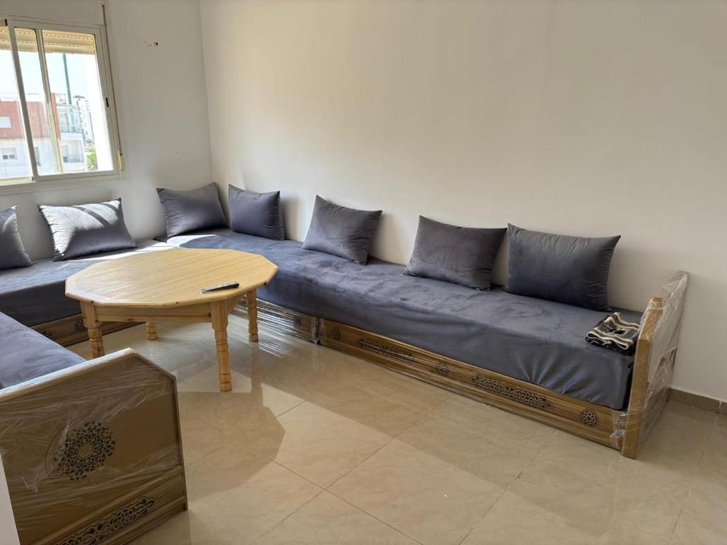 a living room with a blue couch and a table at Appartement entier 1min de la plage sable d'or in Tangier