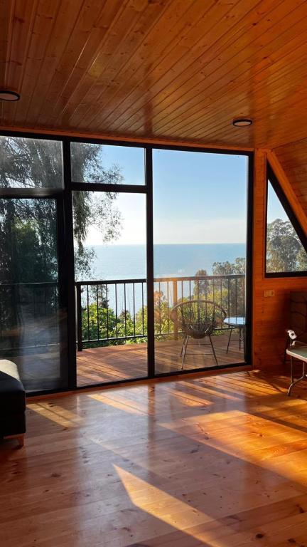 a large room with a view of the ocean at Magnolia Cottage in Ts'ikhisdziri