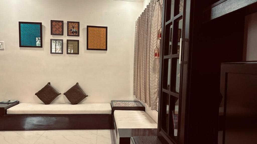 a room with a couch with pillows on it at Nasik Homestay in Nashik