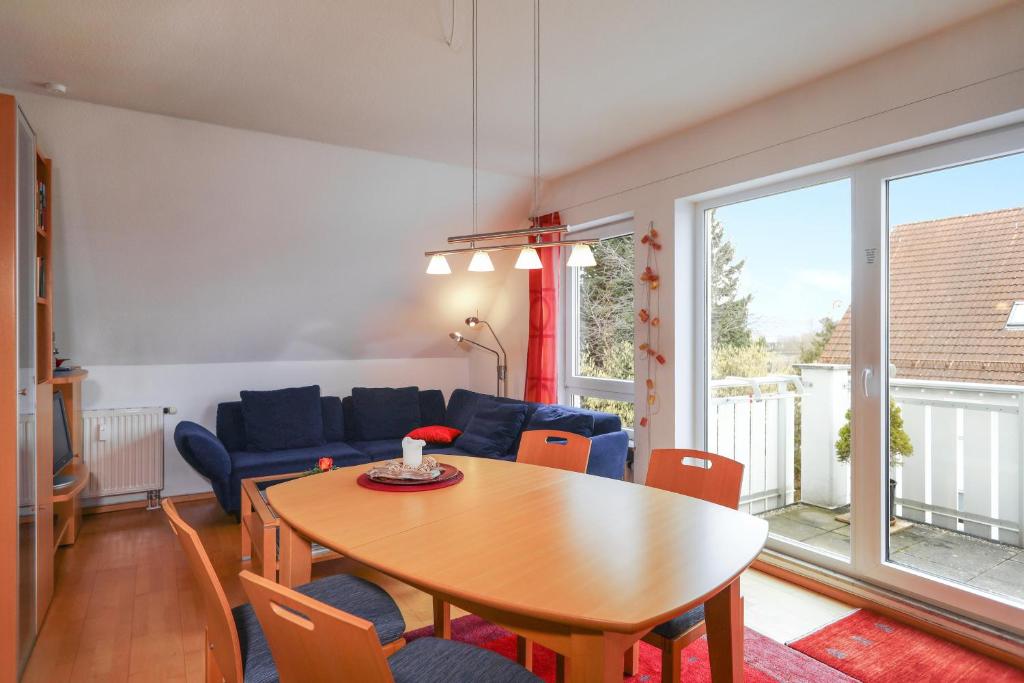 a living room with a table and a blue couch at Ferienwohnung Argenpark Kressbronn in Kressbronn am Bodensee