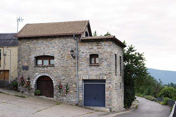 a stone house with a garage and a driveway at Casa Rural GABARDA in Aso de Sobremonte