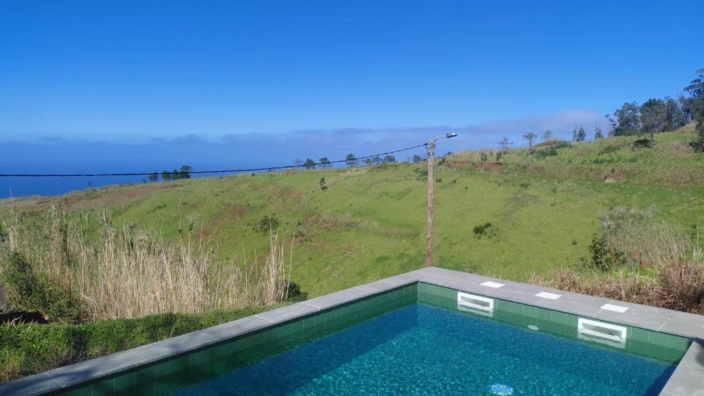 a swimming pool on the side of a hill at Casas do Pargo- Casa A - Oak Tree House in Lombada Velha