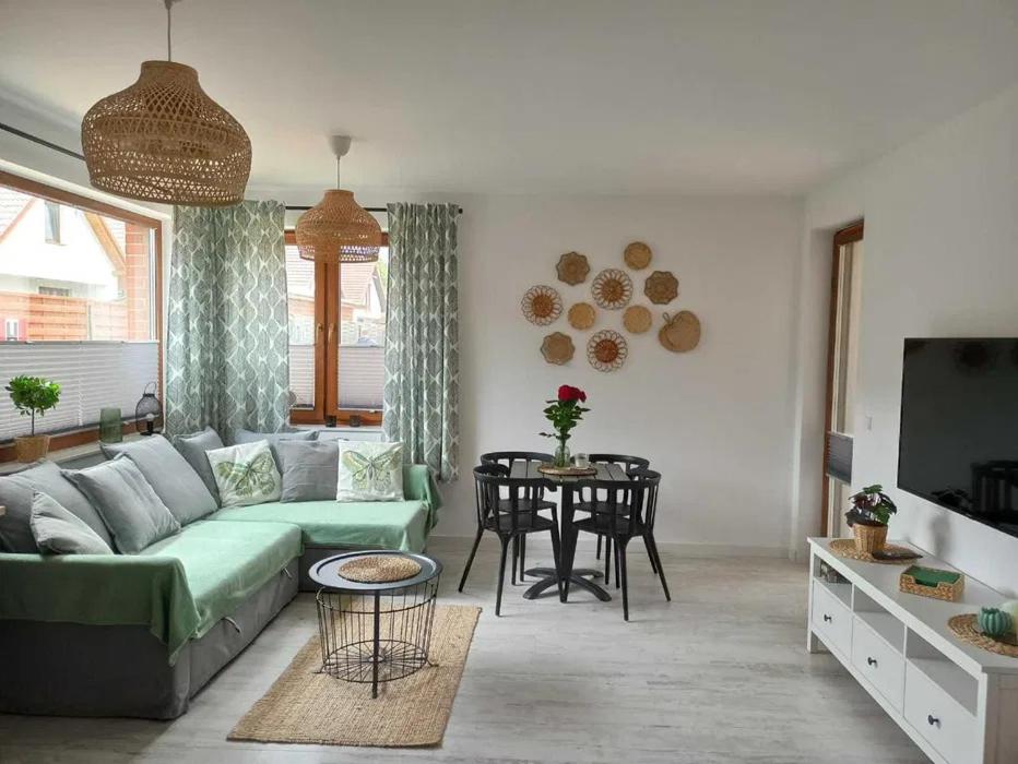 a living room with a green couch and a table at Apartament łeba in Żarnowska