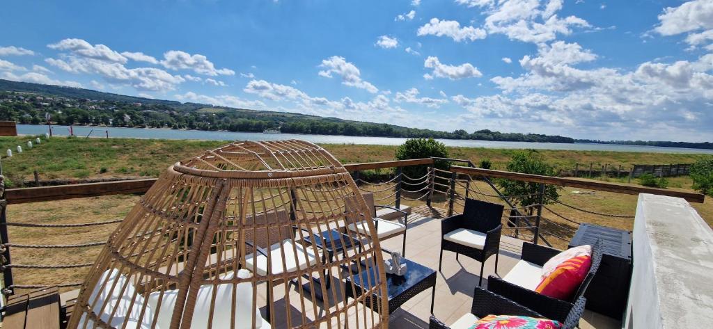 a bird cage on a balcony with a view of a river at Dãnu Guesthouse in Kravany nad Dunajom