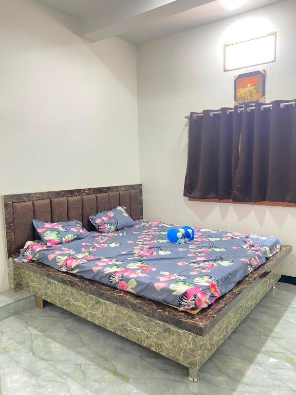 a bed in a room with a blue comforter on it at Hotel Arpita in Ashta