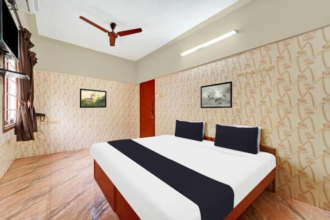 a bedroom with a large bed in a room at Peralam Rooms in Peralam Junction