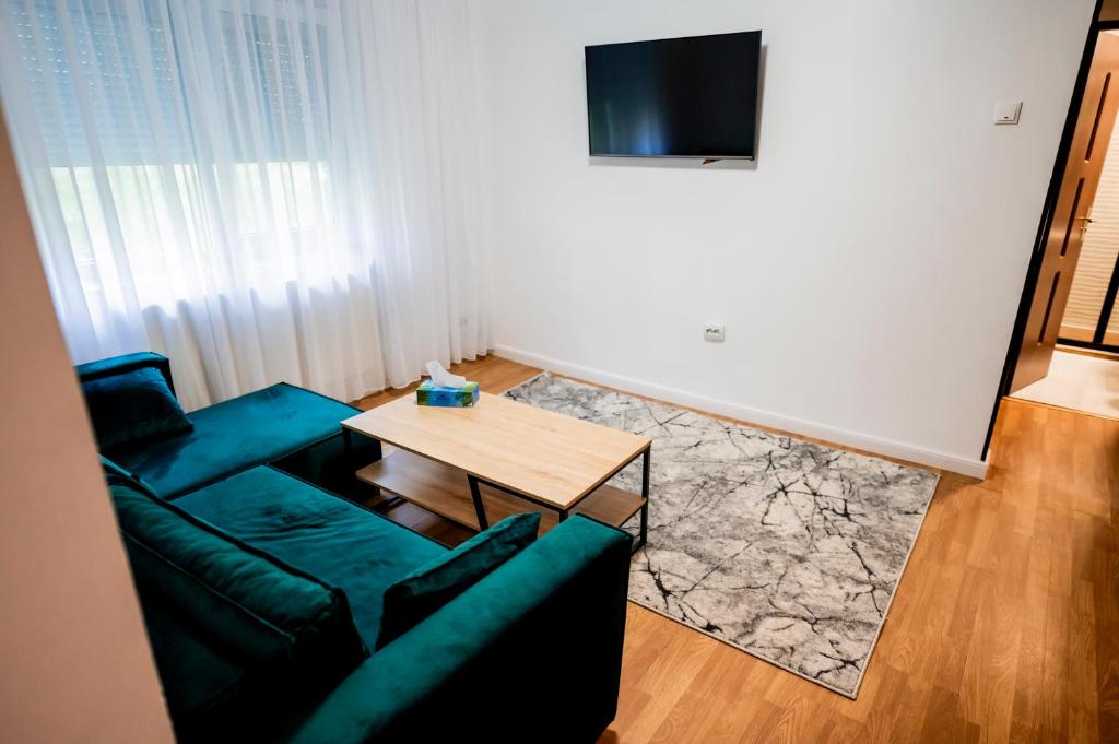 a living room with a green couch and a table at Apartament Ritmului in Zalău