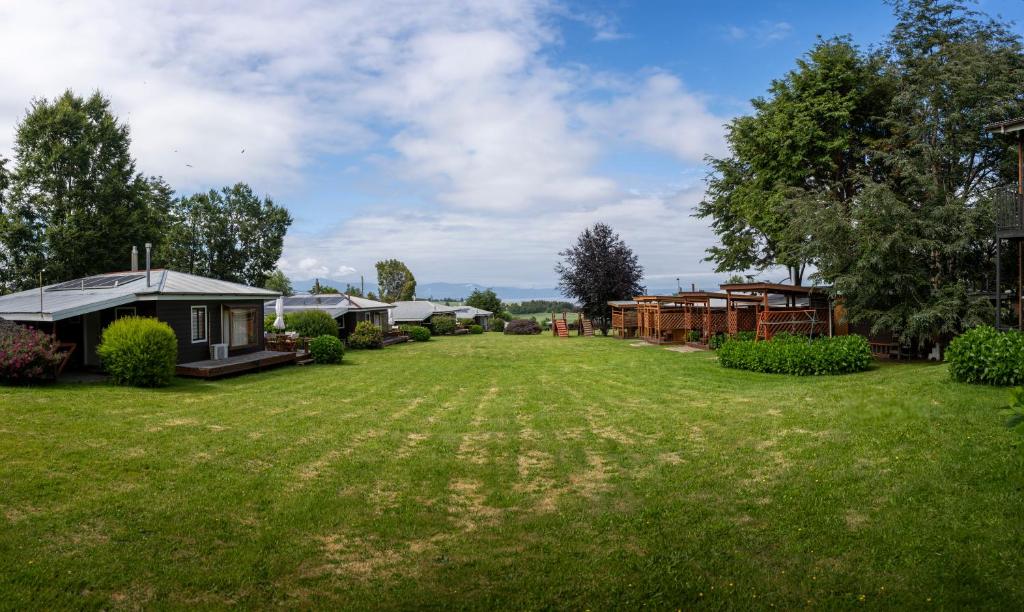 a large yard with a row of cottages at Centro Turistico Lafquintue in Ranco