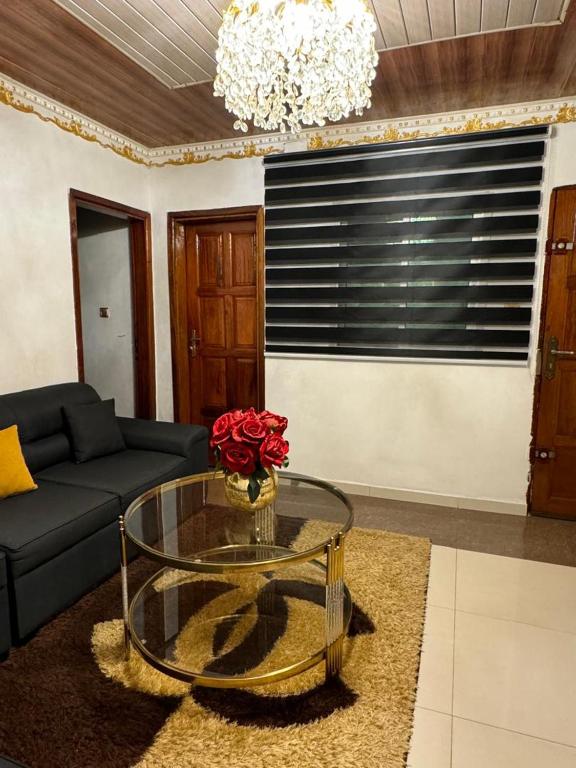 a living room with a couch and a glass table at AFRAAH GUEST House 2 in Yaoundé