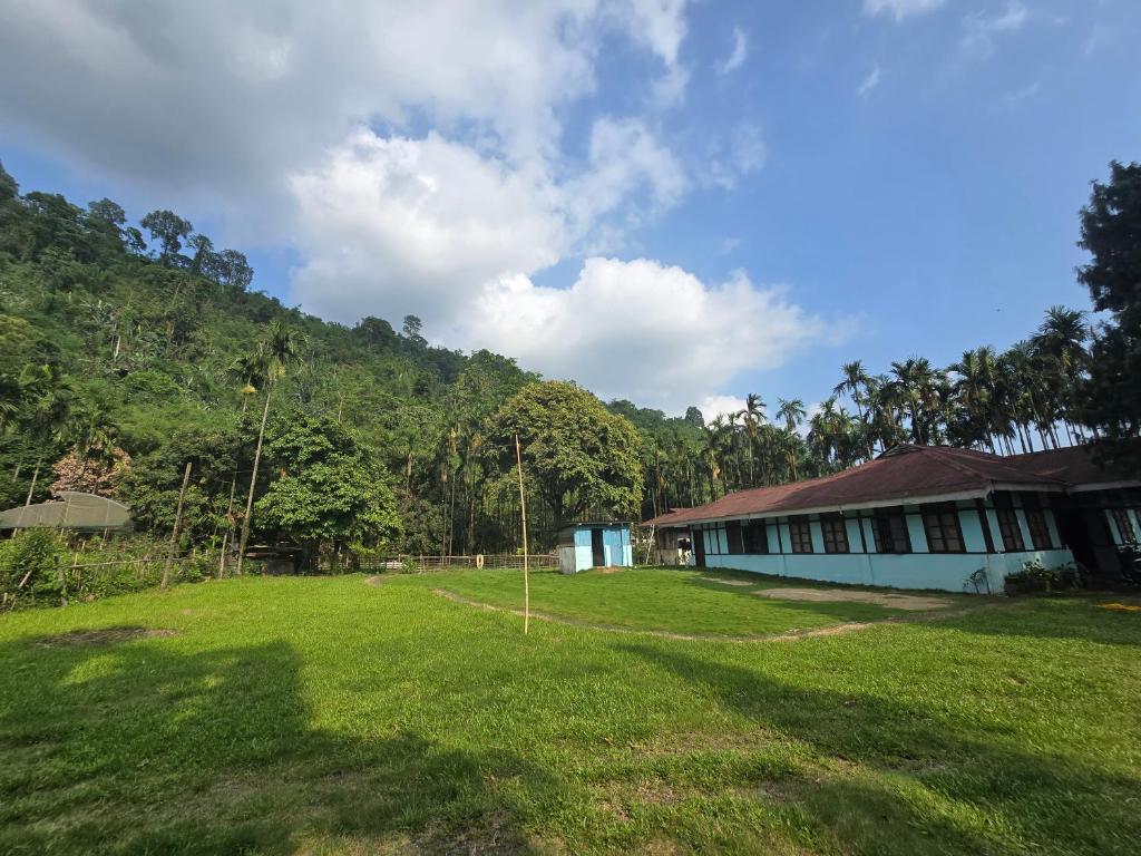 a house in a field next to a forest at Eya Nest Homestay in Mekha