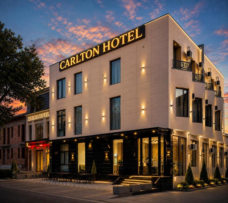 a hotel building with a sign that reads caution hotel at Carlton Hotel Tashkent in Tashkent