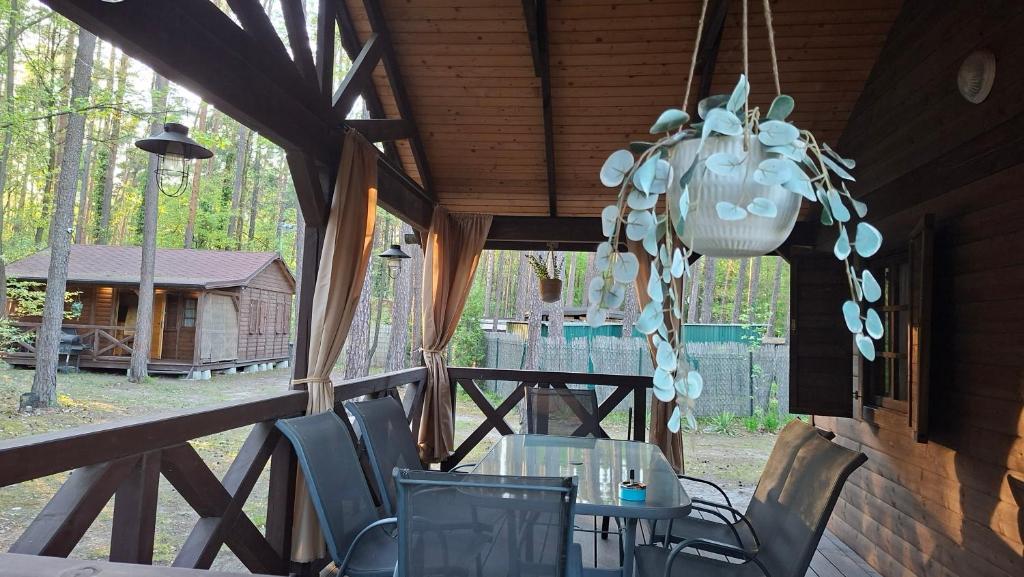 a table and chairs on the porch of a cabin at Domek w Turawie in Turawa
