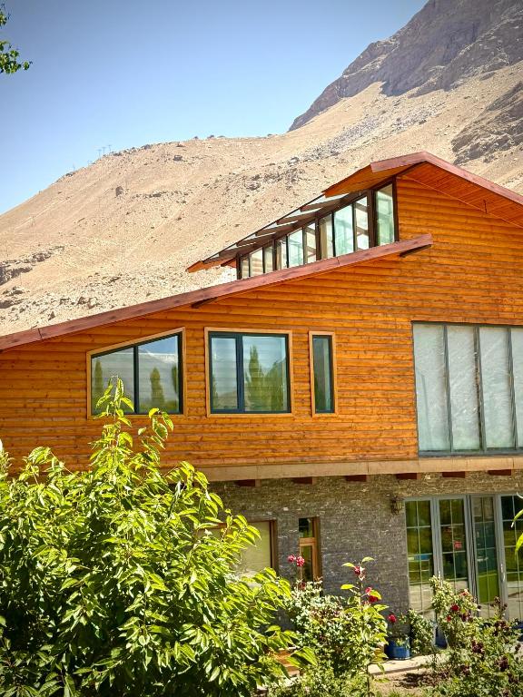 a wooden house with a mountain in the background at 2149 Hotel in Khorog