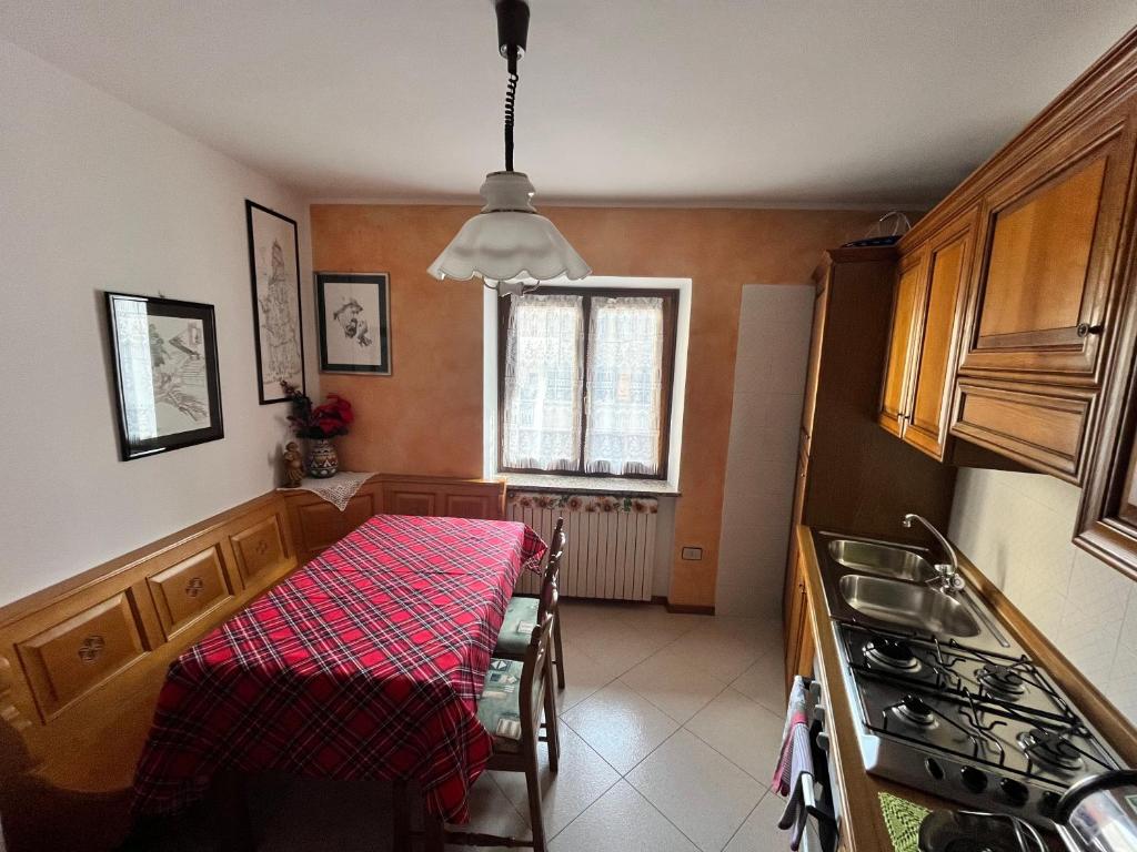 a kitchen with a table with a red table cloth at Casa Adry in Cles