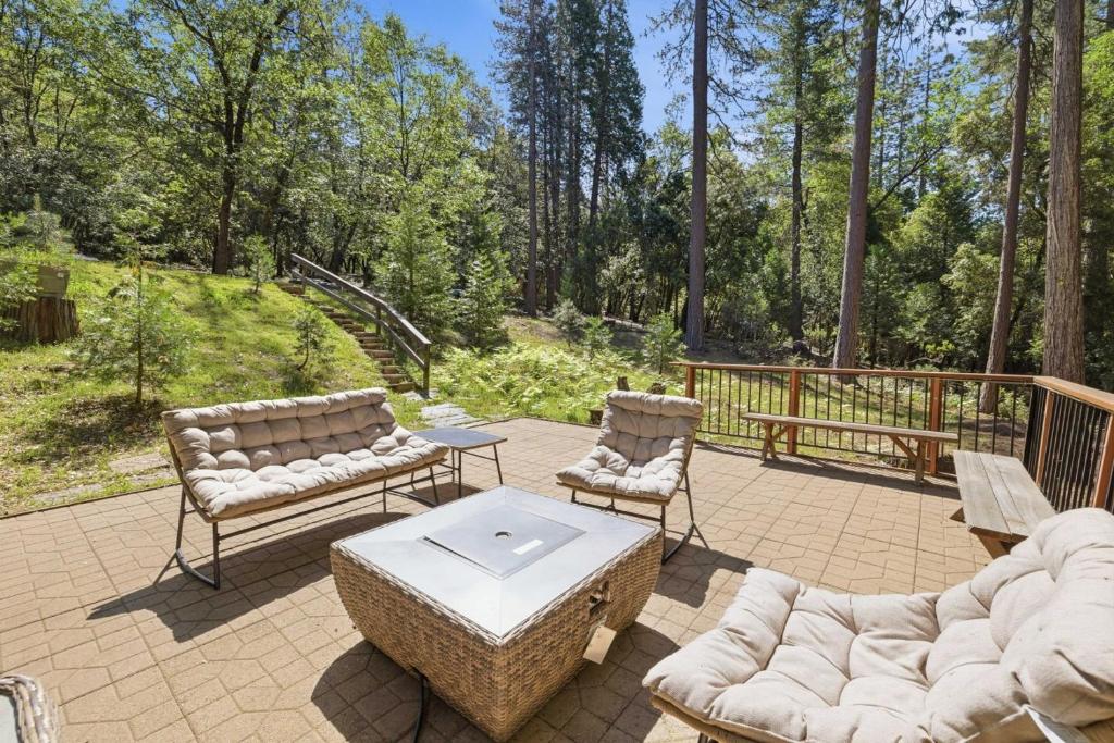 a patio with two couches and a table and chairs at Flatlanders Retreat in Twain Harte