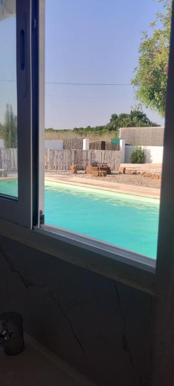 a view of a swimming pool through a window at L'évidence in Alcantarilha
