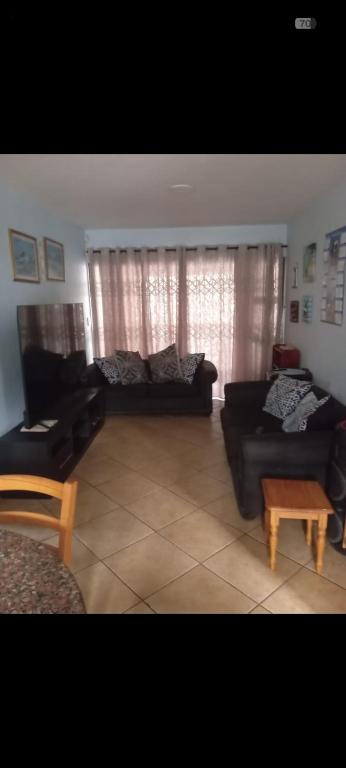 a living room with couches and a coffee table at Hibberdene See to Sea in Hibberdene