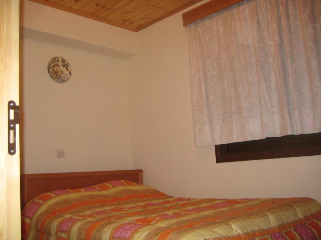 een slaapkamer met een bed en een raam bij Flora's House in Spilia