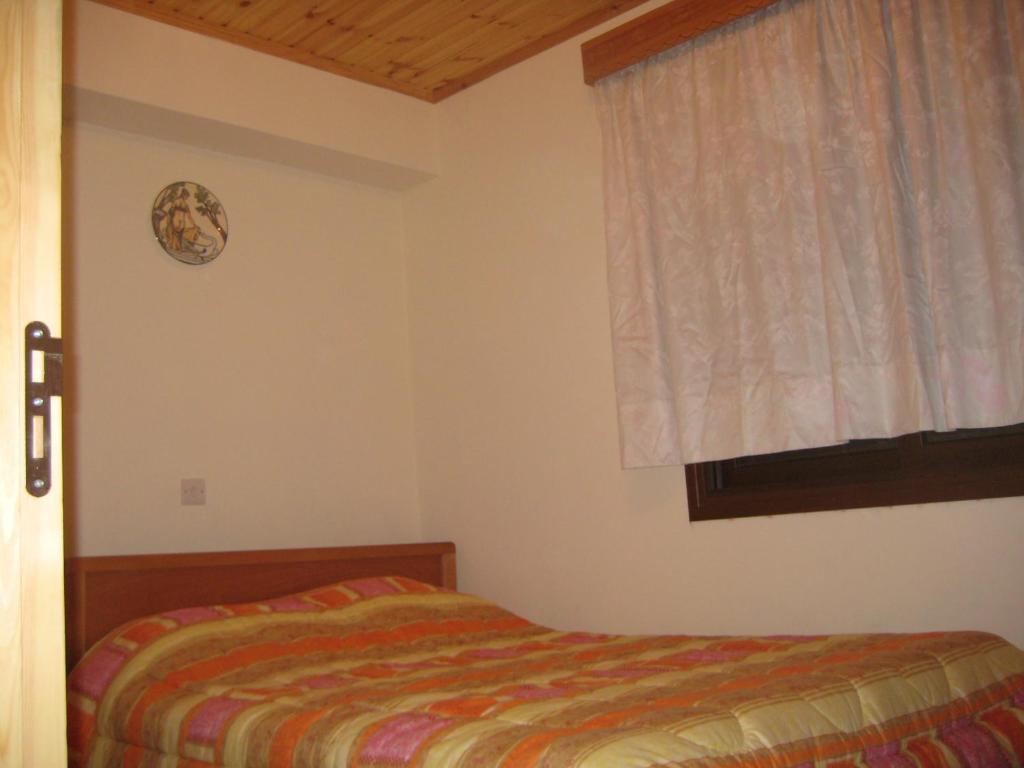 a bedroom with a bed and a window at Flora's House in Spilia