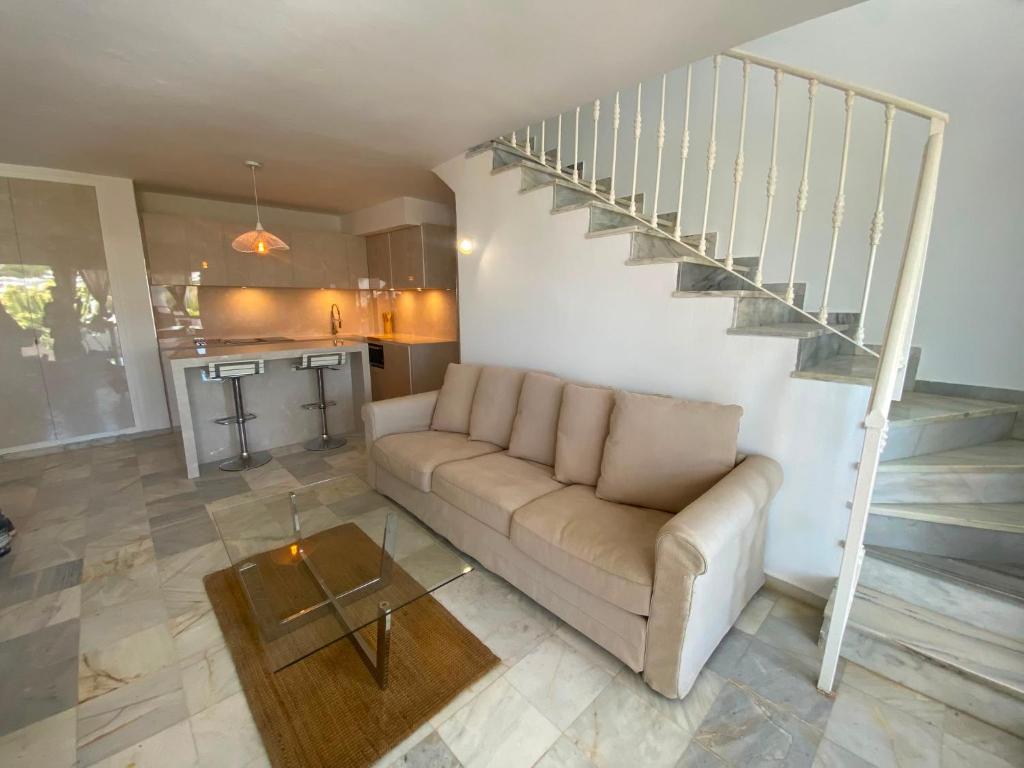 a living room with a couch and a staircase at Marbella Sunseat apartment in Marbella