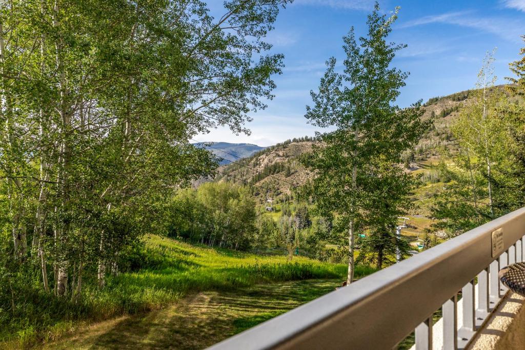 a railing on a road with mountains in the background at Walk to Beaver Creek Village - 2BR Condo with Chairlift Views, Pool & Hot Tub in Beaver Creek
