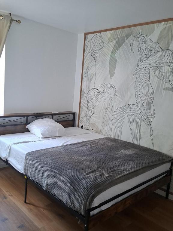 a bedroom with a bed with a large mural on the wall at Naëlle in Calais