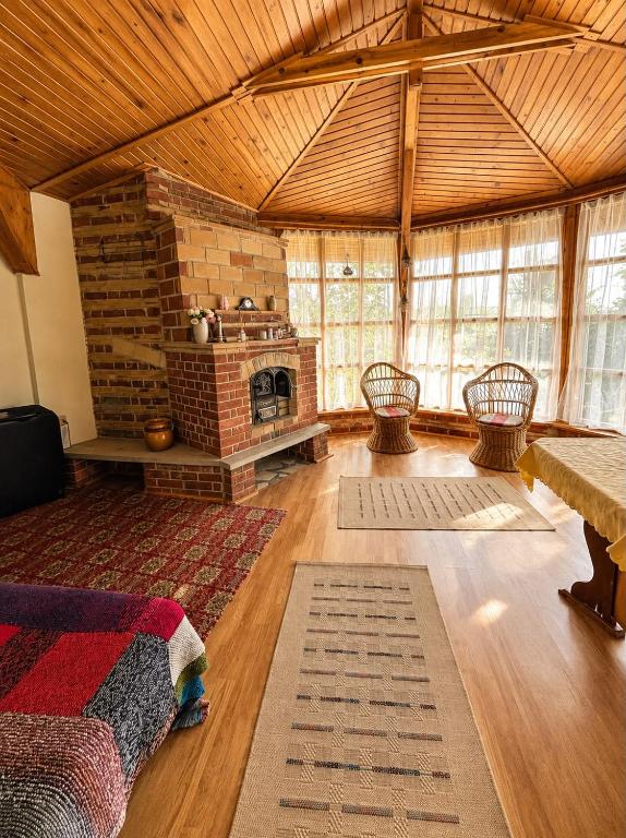 a large room with a brick fireplace in a building at Casa cu şemineu in Păuşa