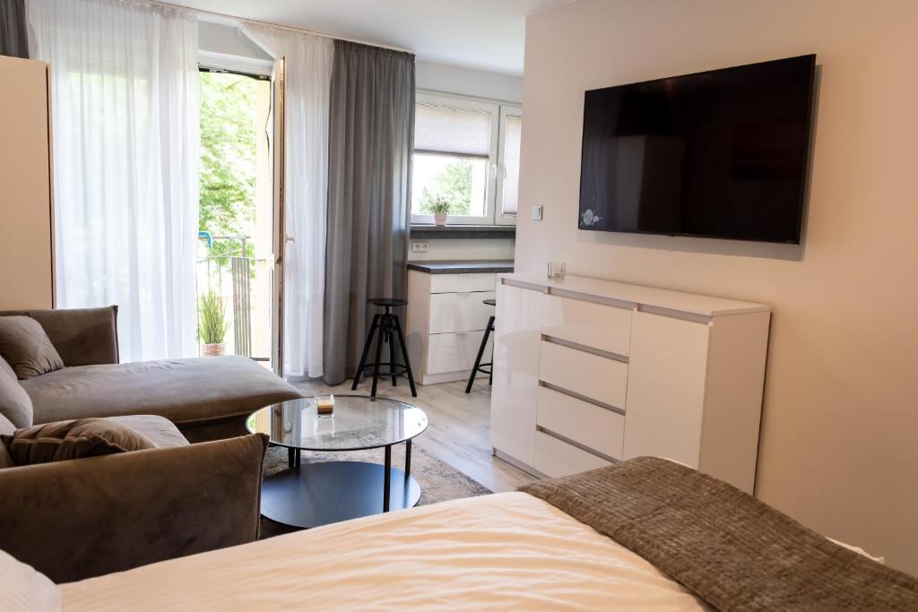 a living room with a couch and a flat screen tv at Apartament Targowa 9A41 in Uniejow