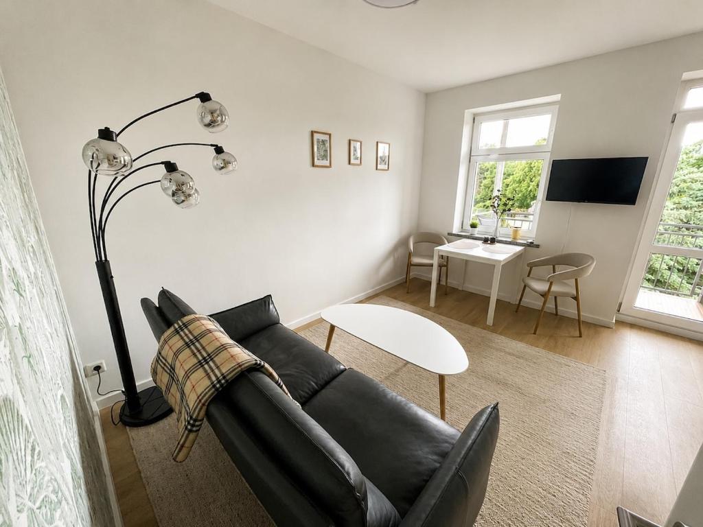 a living room with a black couch and a table at Modernes Design-Apartment mit Balkon & WLAN in Bautzen