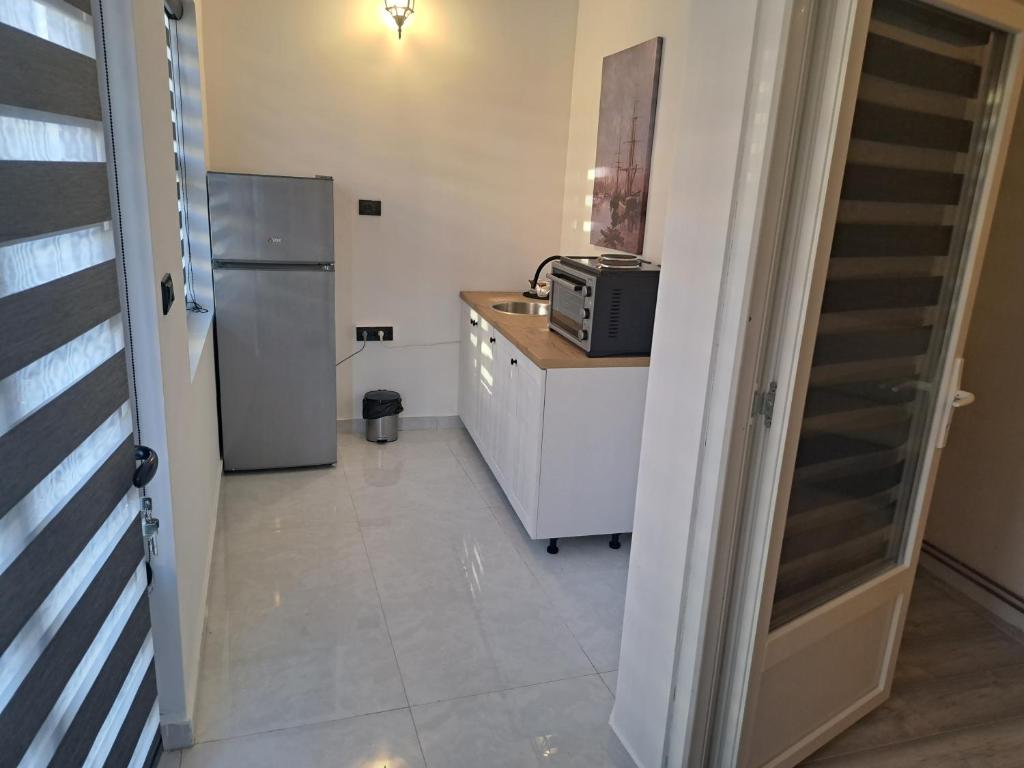 a kitchen with a refrigerator and a counter with a microwave at Stefanovic in Valjevo