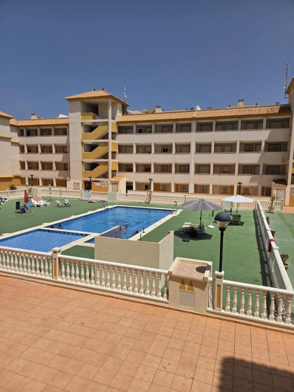 a large building with a swimming pool in front of it at Mar de Cristal in Mar de Cristal